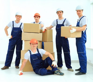 Professional team handling piano removals in Roehampton with protective wrapping