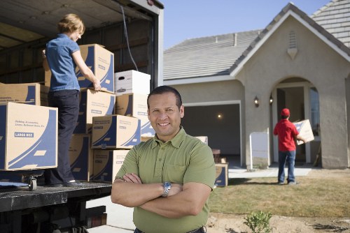 Professional mover loading furniture into a van in Roehampton