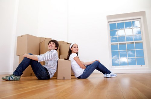 Professional house movers carrying furniture in a Roehampton property