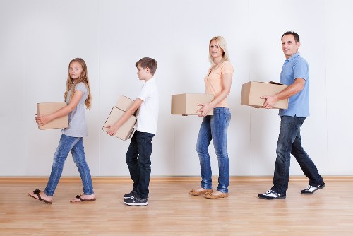 Movers carrying furniture from a family house in Roehampton
